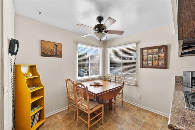 dining area with baseboards and ceiling fan