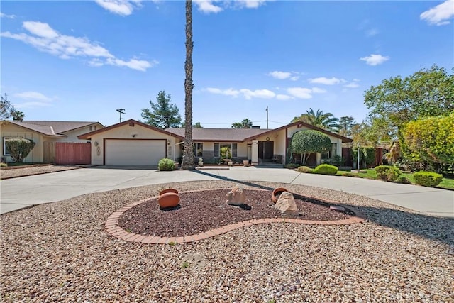 ranch-style house featuring stucco siding, an attached garage, fence, and concrete driveway