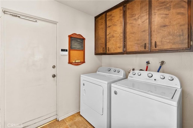 clothes washing area with washing machine and dryer, cabinet space, and light tile patterned floors