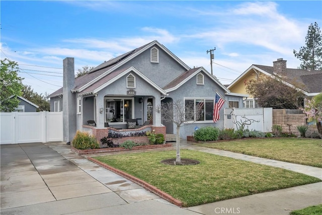 bungalow-style house with stucco siding, a chimney, a gate, a front yard, and fence