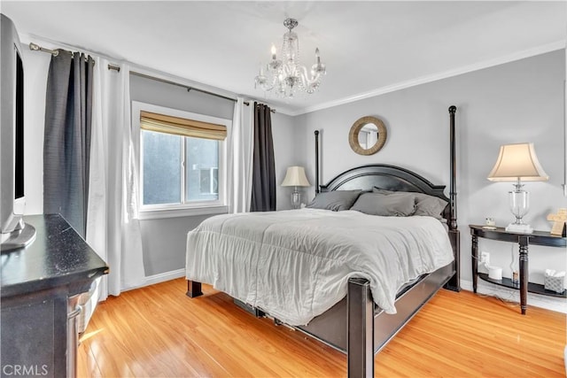 bedroom with a chandelier, light wood-style floors, crown molding, and baseboards