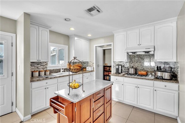 630 King St, Monrovia, CA 91016 - kitchen with under cabinet range hood, gas stovetop, light tile patterned flooring, tasteful backsplash, and recessed lighting