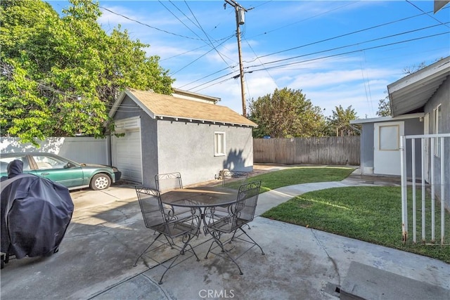 view of patio / terrace featuring outdoor dining area, fence, and an outdoor structure
