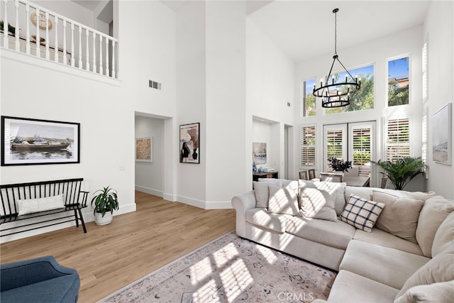 19732 Torres, Lake Forest, CA 92679 - living room featuring a chandelier, a towering ceiling, wood finished floors, and baseboards