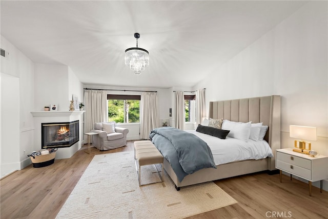 19732 Torres, Lake Forest, CA 92679 - bedroom featuring wood finished floors, a chandelier, and a glass covered fireplace
