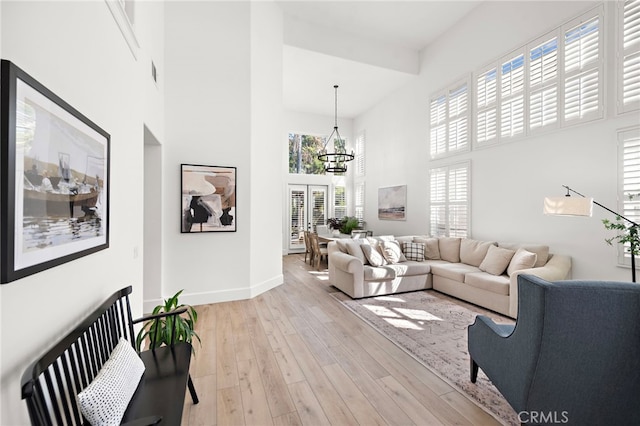 19732 Torres, Lake Forest, CA 92679 - living room with a towering ceiling, a chandelier, light wood finished floors, and baseboards