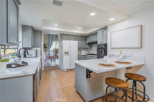 kitchen featuring a peninsula, gray cabinets, visible vents, white appliances, and crown molding