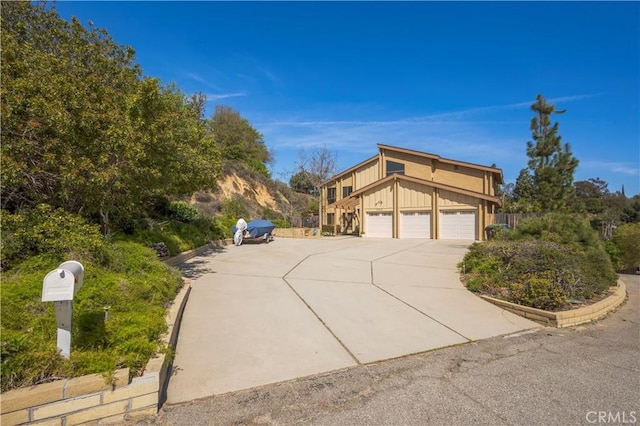 view of property exterior featuring board and batten siding, driveway, and a garage