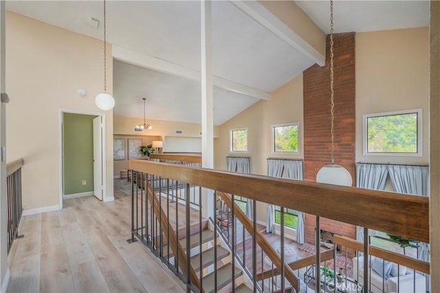 hall with high vaulted ceiling, an upstairs landing, light wood-style floors, beamed ceiling, and baseboards