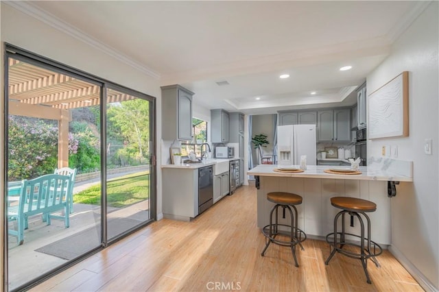 kitchen with ornamental molding, a peninsula, gray cabinetry, and black appliances