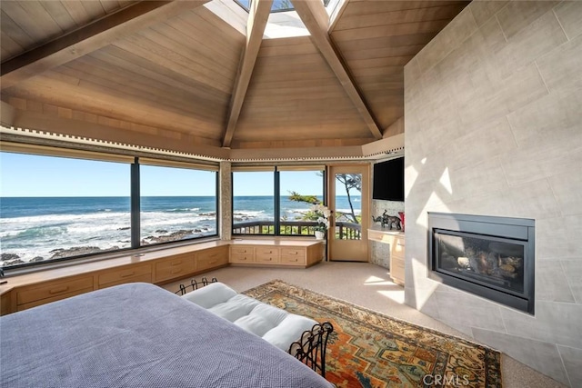 2431 Sherwood Dr, Cambria, CA 93428 - bedroom with lofted ceiling with beams, a tiled fireplace, light carpet, access to exterior, and wood ceiling