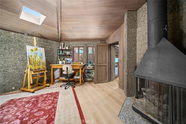 2431 Sherwood Dr, Cambria, CA 93428 - office area featuring a skylight, wood finished floors, a wood stove, and wooden ceiling