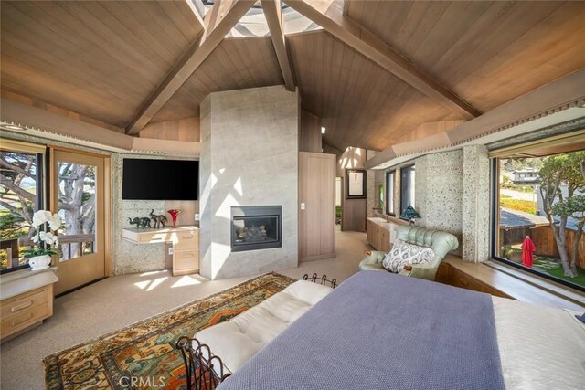 2431 Sherwood Dr, Cambria, CA 93428 - carpeted bedroom with lofted ceiling with beams, a glass covered fireplace, wood ceiling, and access to outside