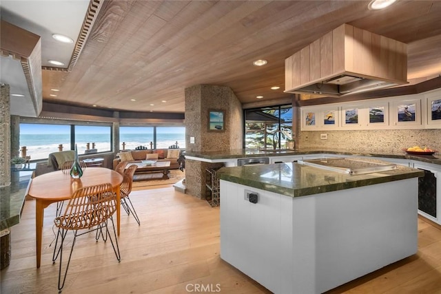 2431 Sherwood Dr, Cambria, CA 93428 - kitchen featuring wooden ceiling, backsplash, a kitchen island, light wood-style floors, and stovetop