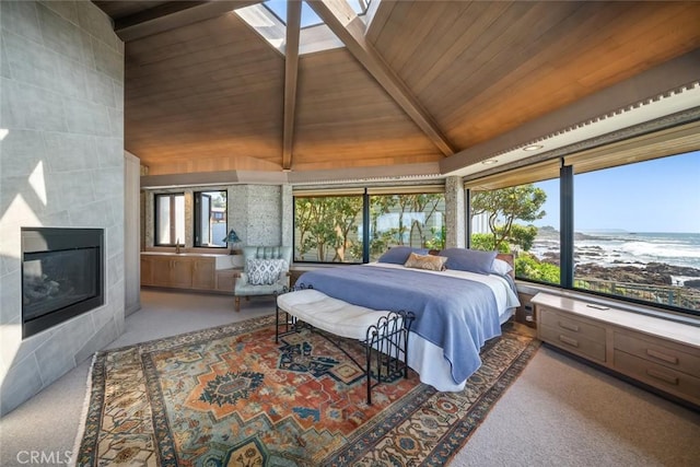 2431 Sherwood Dr, Cambria, CA 93428 - carpeted bedroom with high vaulted ceiling, a tiled fireplace, wood ceiling, and beam ceiling