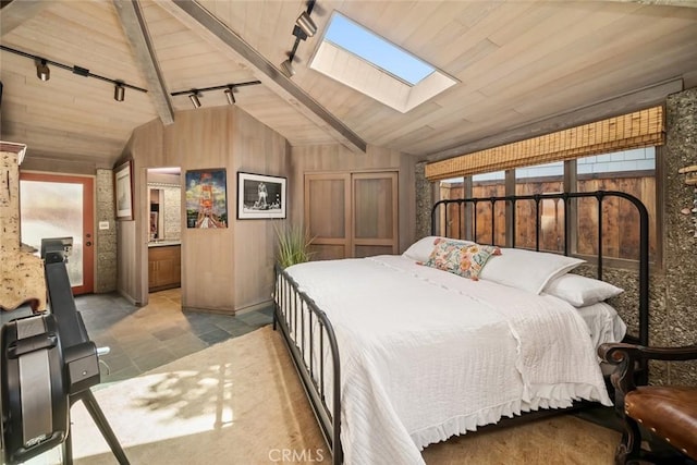 2431 Sherwood Dr, Cambria, CA 93428 - bedroom featuring rail lighting, vaulted ceiling with skylight, wooden ceiling, and wood walls