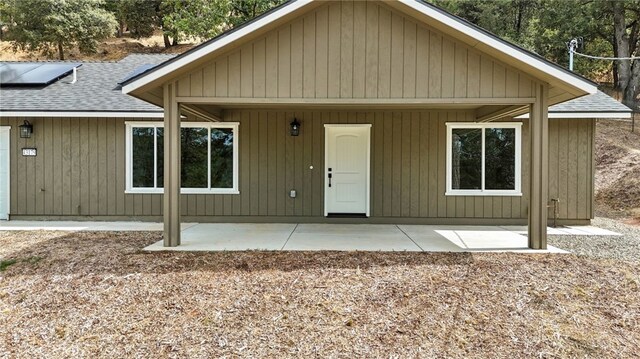 43179 E Sugar Pine Dr, Oakhurst, CA 93644 - view of front facade featuring roof mounted solar panels, a patio, and roof with shingles