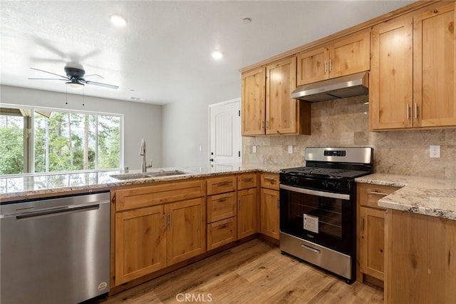 43179 E Sugar Pine Dr, Oakhurst, CA 93644 - kitchen with a peninsula, light stone countertops, stainless steel appliances, under cabinet range hood, and a sink