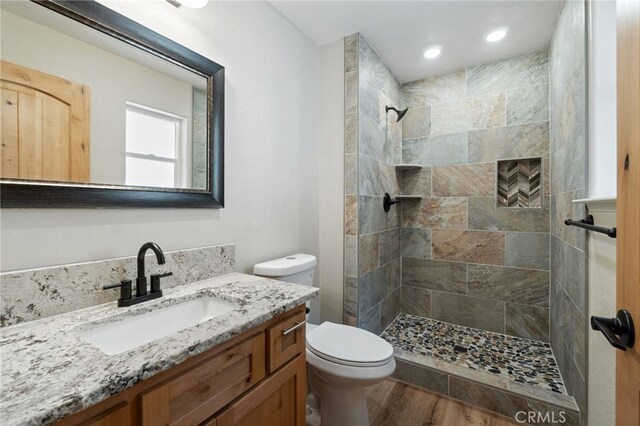 43179 E Sugar Pine Dr, Oakhurst, CA 93644 - bathroom with toilet, a tile shower, recessed lighting, vanity, and wood finished floors