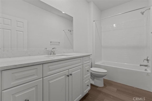 bathroom featuring shower / washtub combination, vanity, toilet, and wood finished floors