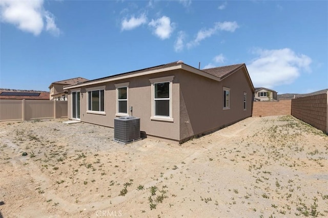 back of property featuring a fenced backyard and cooling unit