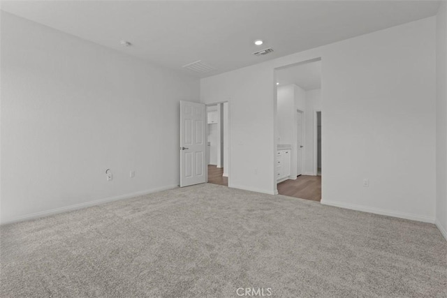 unfurnished bedroom with carpet, visible vents, and baseboards