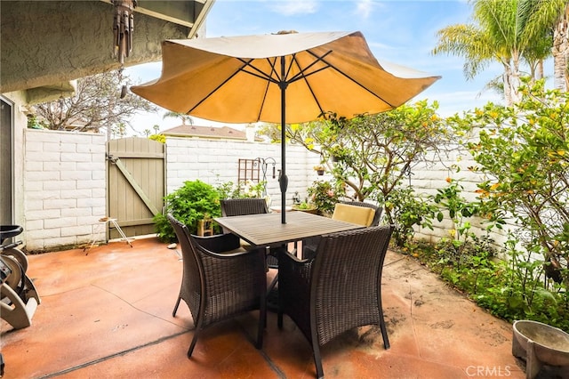 18815 Thornwood Cir Unit Ci32, Huntington Beach, CA 92646 - view of patio / terrace with a gate, outdoor dining space, and fence