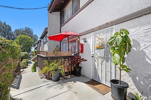 doorway to property with a patio area and stucco siding