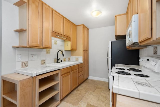 kitchen with tile countertops, open shelves, a sink, baseboards, and white appliances