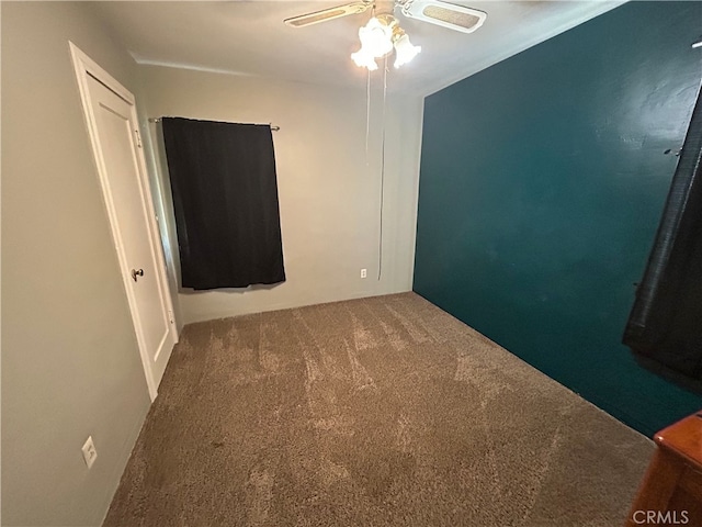 unfurnished room with ceiling fan and carpet