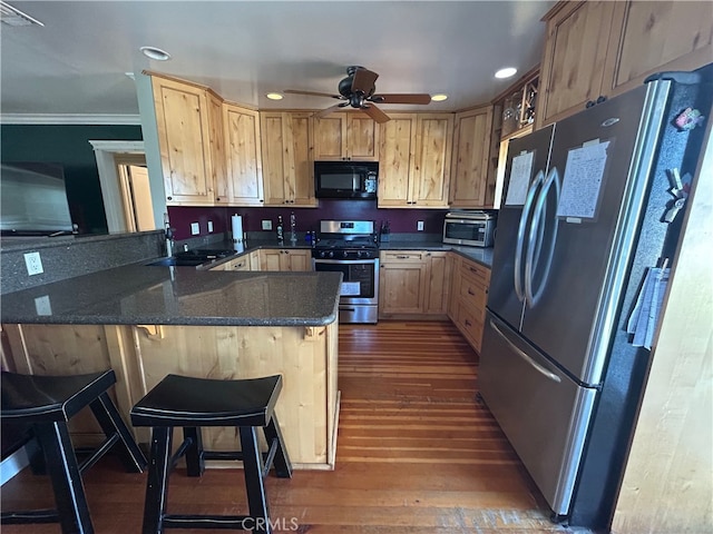 kitchen featuring crown molding, ceiling fan, a peninsula, appliances with stainless steel finishes, and dark wood-style floors