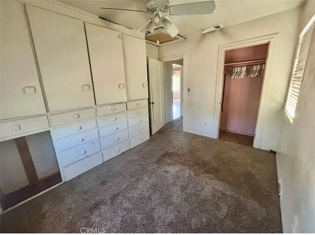 unfurnished bedroom featuring a closet, visible vents, carpet flooring, and ceiling fan