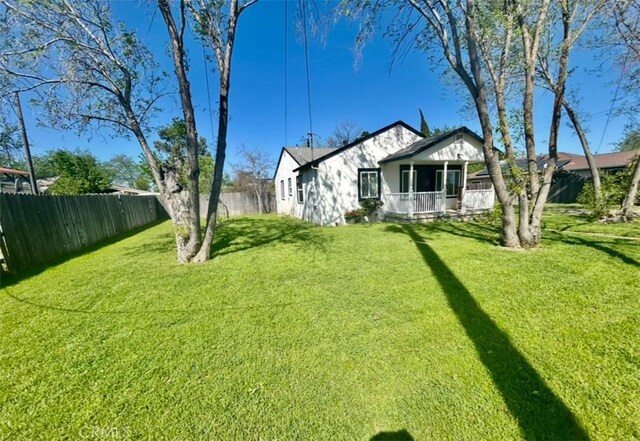 view of yard featuring a porch and fence