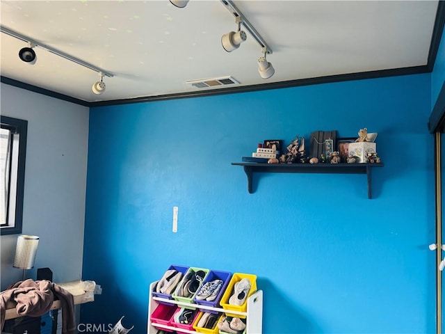 bedroom with rail lighting and visible vents