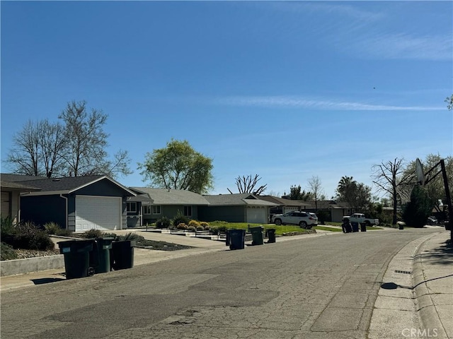 view of road with a residential view, sidewalks, and curbs