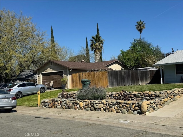 view of front of house featuring fence, a front yard, and a garage