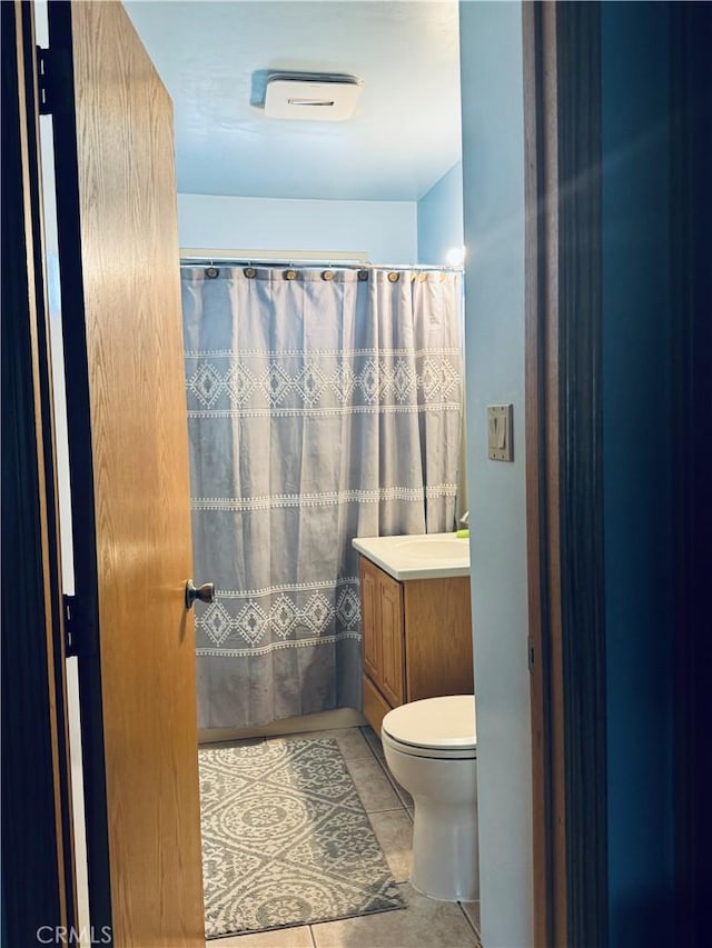 bathroom featuring a shower with curtain, vanity, tile patterned flooring, and toilet