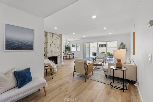 7042 Stonewood Dr, Huntington Beach, CA 92647 - living room featuring a notable chandelier, a fireplace, light wood-type flooring, baseboards, and recessed lighting
