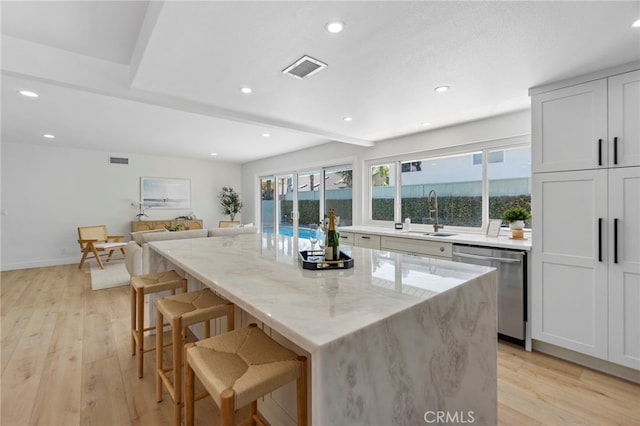 7042 Stonewood Dr, Huntington Beach, CA 92647 - kitchen featuring light stone countertops, a sink, light wood-type flooring, and dishwasher
