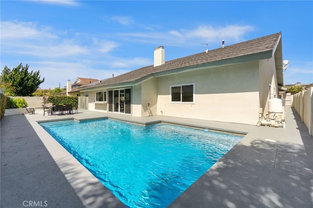 7042 Stonewood Dr, Huntington Beach, CA 92647 - rear view of property with a patio, a chimney, a fenced in pool, a fenced backyard, and stucco siding