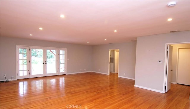 spare room featuring baseboards, light wood-type flooring, recessed lighting, and french doors