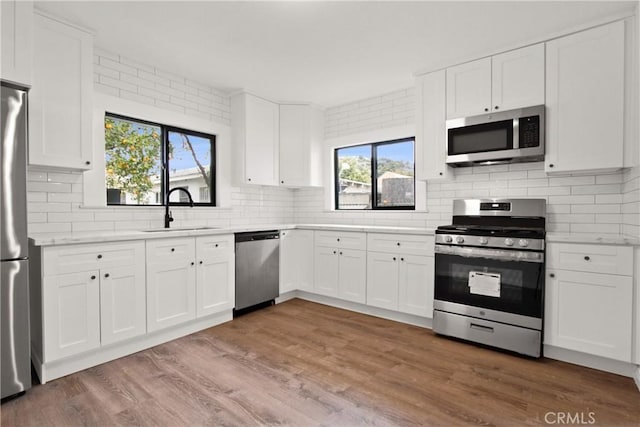 2619 Alice St, Los Angeles, CA 90065 - kitchen with light countertops, a sink, tasteful backsplash, wood finished floors, and appliances with stainless steel finishes