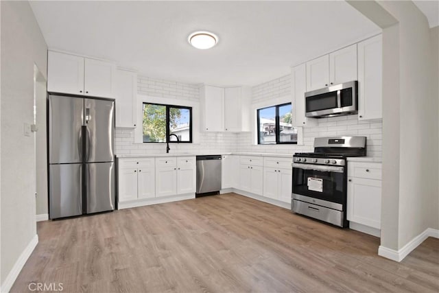 2619 Alice St, Los Angeles, CA 90065 - kitchen with light countertops, appliances with stainless steel finishes, light wood-style flooring, decorative backsplash, and a healthy amount of sunlight
