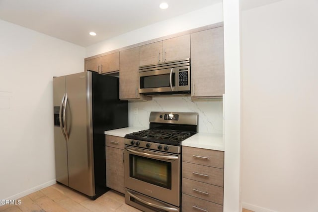 kitchen featuring baseboards, light countertops, recessed lighting, and stainless steel appliances
