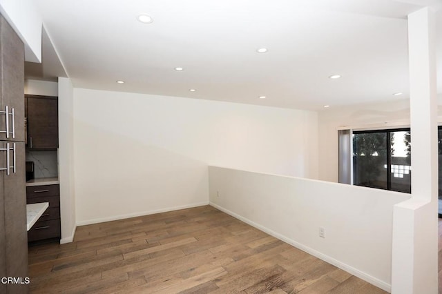 unfurnished room featuring baseboards, recessed lighting, and wood finished floors