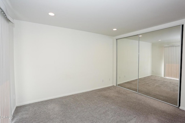 unfurnished bedroom with carpet flooring, recessed lighting, baseboards, and a closet