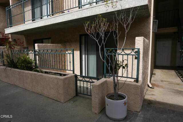 2491 Purdue Ave Unit 111, Los Angeles, CA 90064 - view of exterior entry featuring a balcony and stucco siding