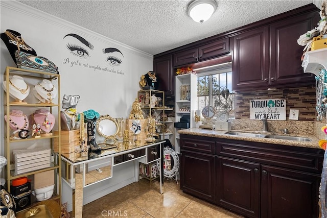 178 E 49th St, Los Angeles, CA 90011 - kitchen featuring light tile patterned flooring, a textured ceiling, crown molding, light stone countertops, and backsplash