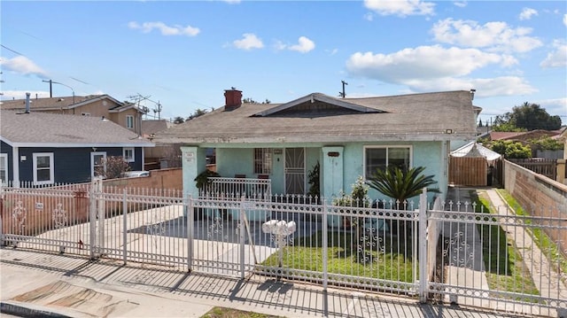 178 E 49th St, Los Angeles, CA 90011 - bungalow-style home with a shingled roof, a chimney, a fenced front yard, and a porch