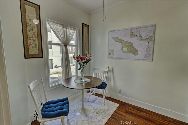 dining room featuring crown molding, dark wood finished floors, and baseboards